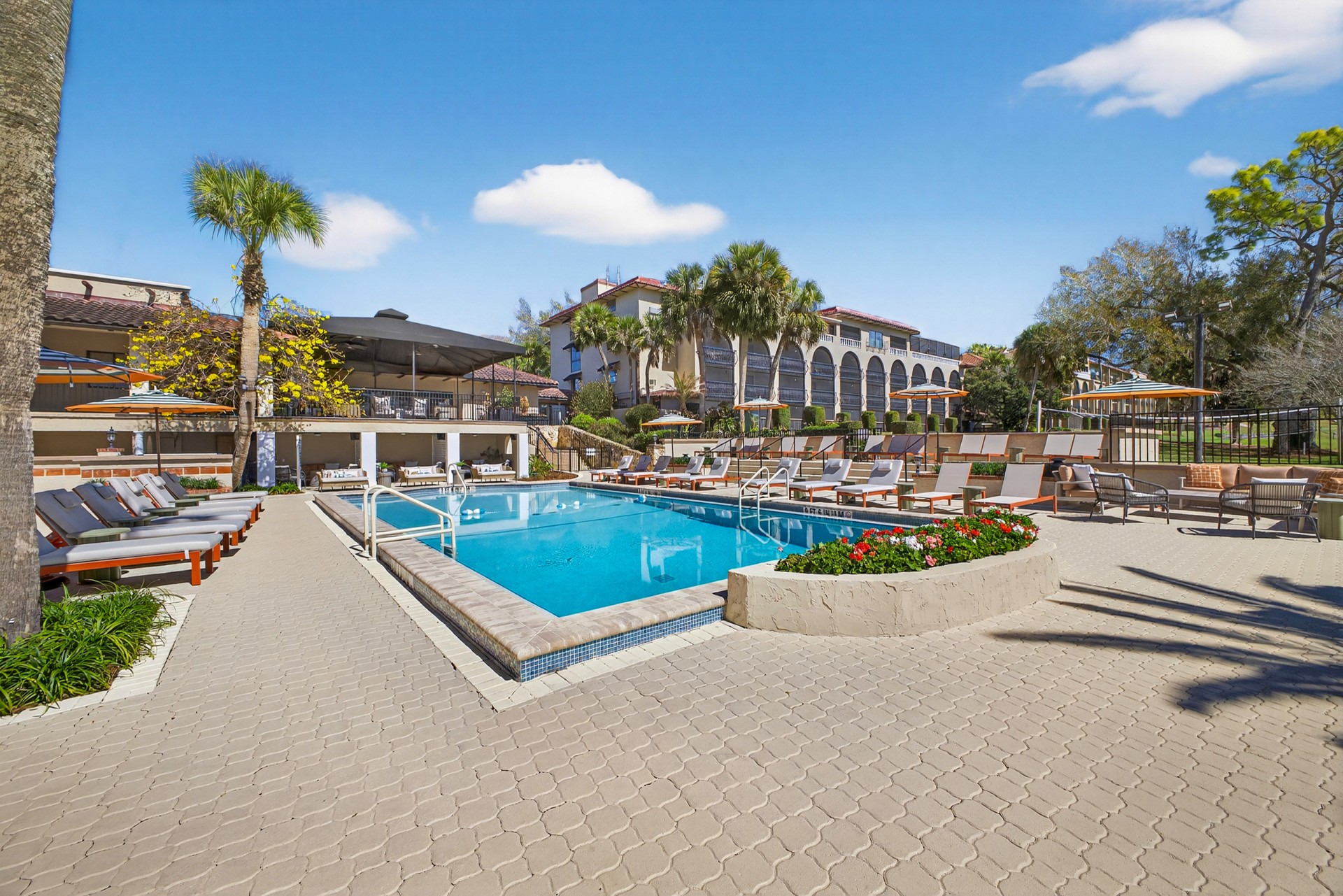 a pool with lounge chairs and a building