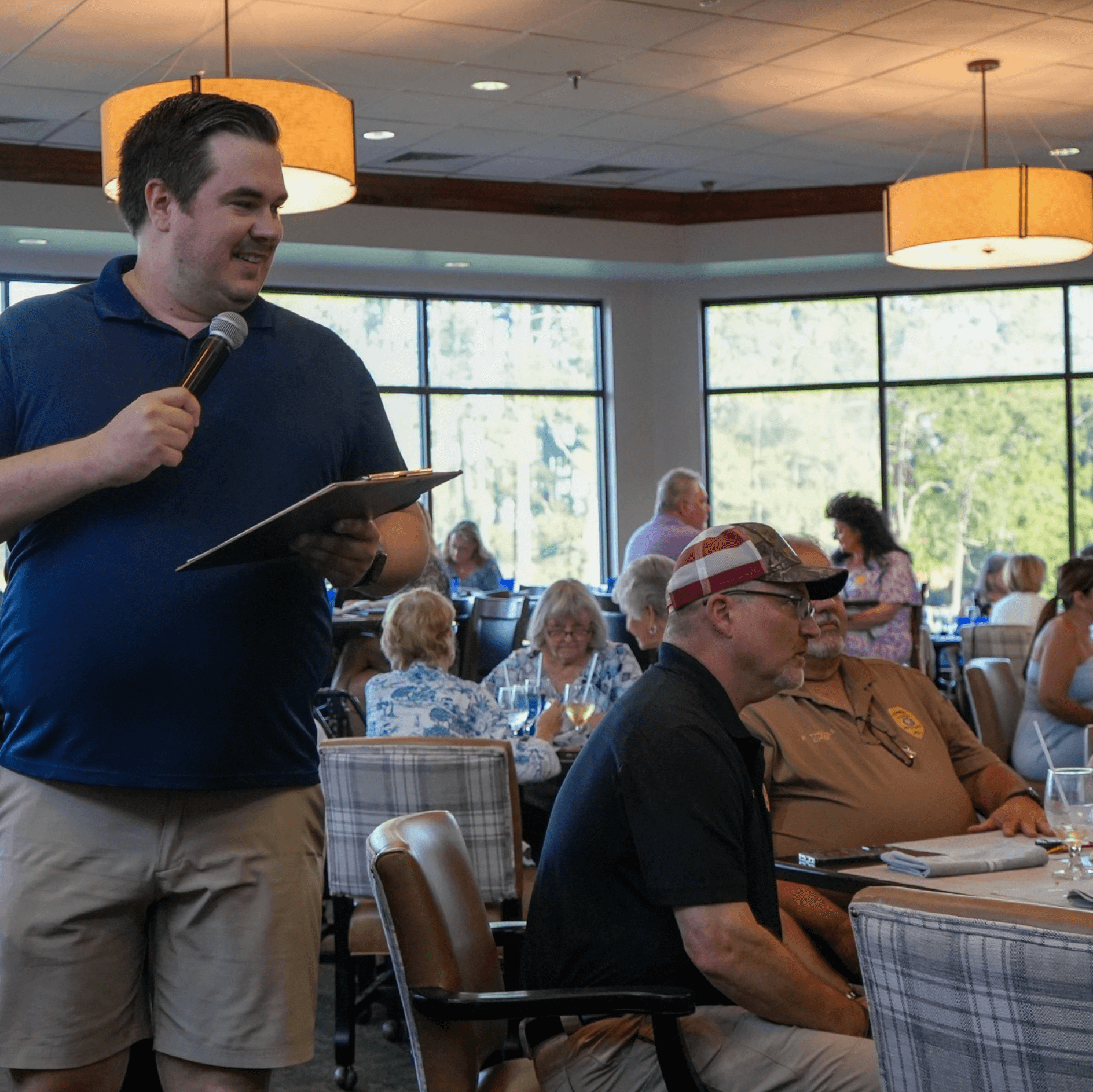 a man holding a microphone and speaking into a microphone
