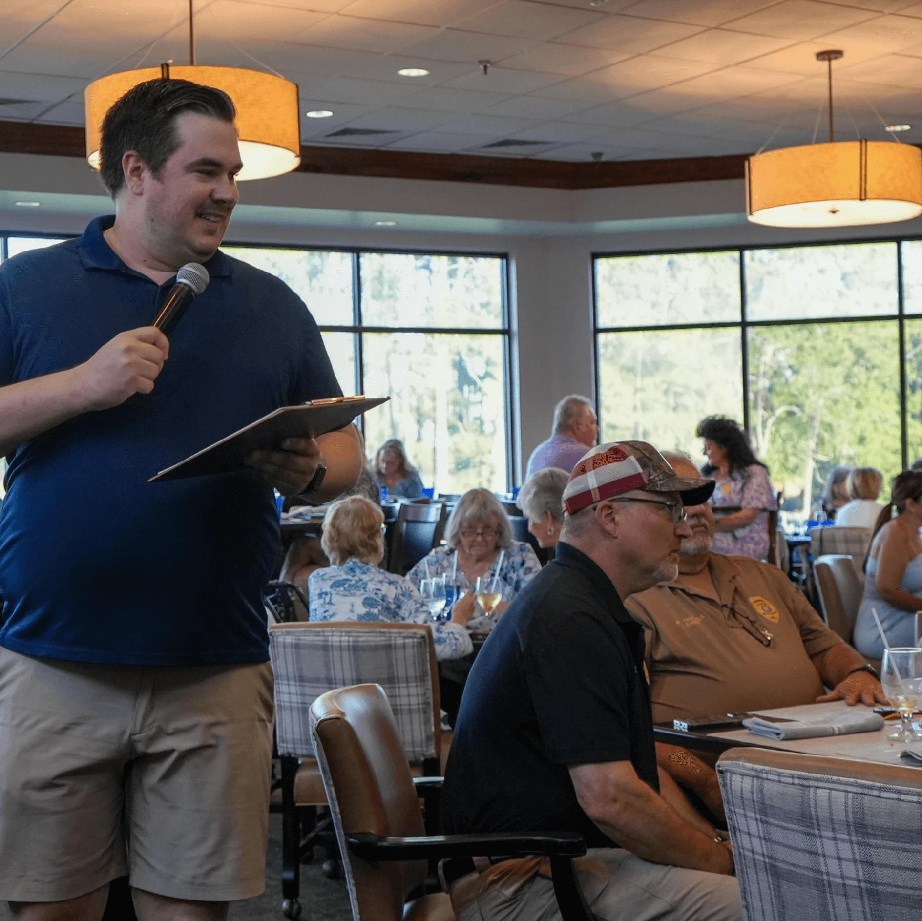 a man holding a microphone and speaking into a microphone