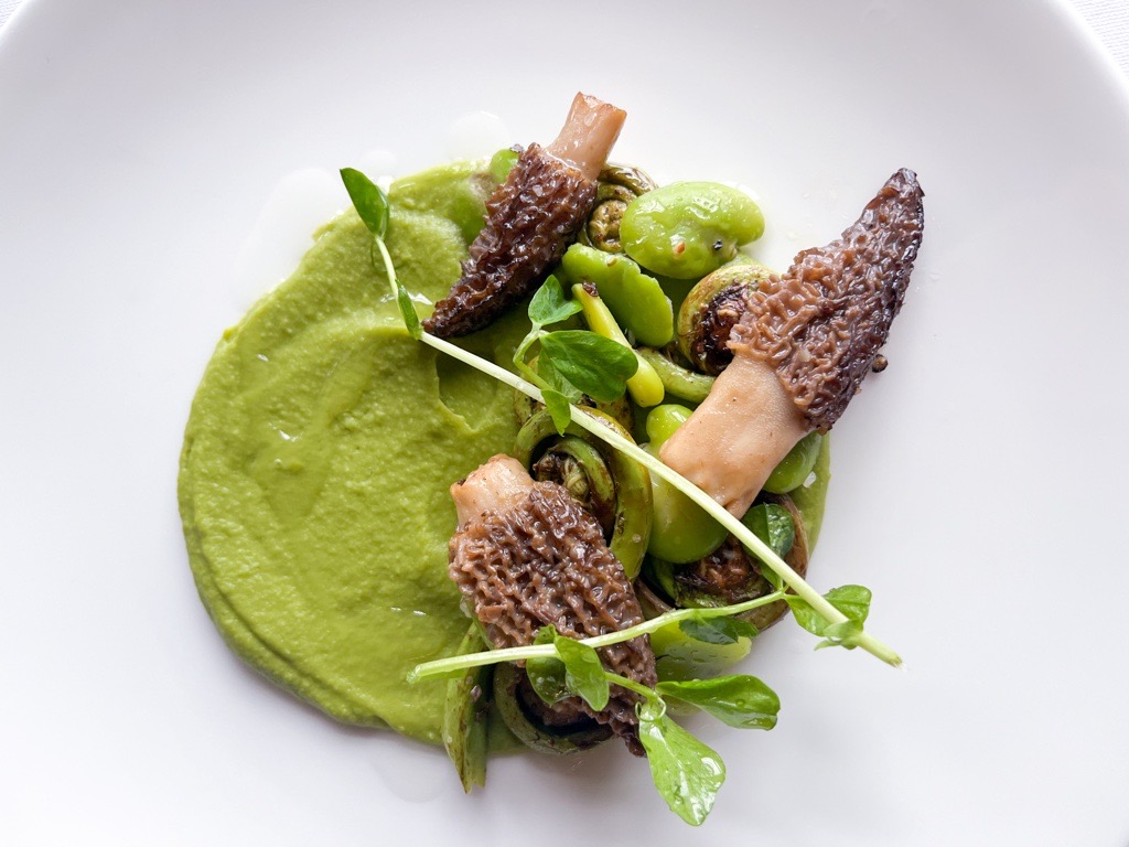 a plate of food with mushrooms and green sauce