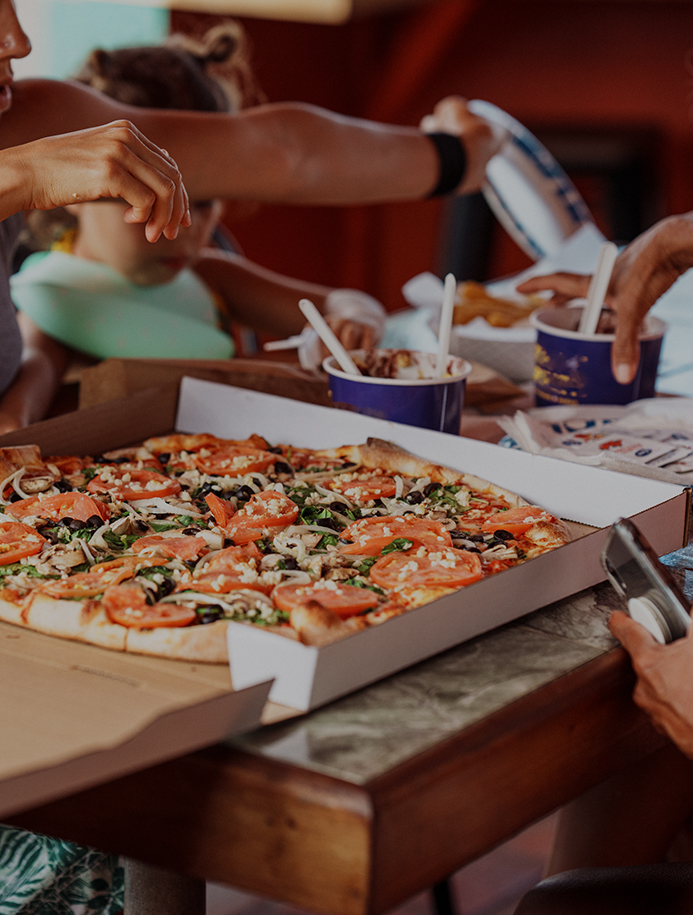 a group of people eating pizza