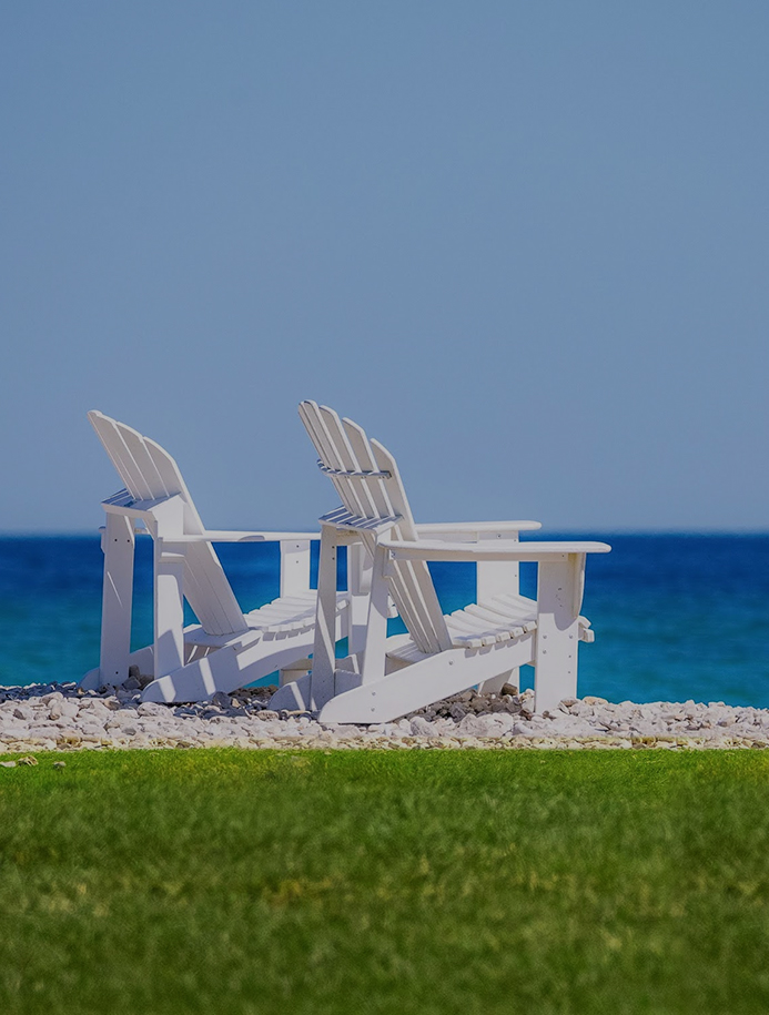 two white chairs on a rocky beach