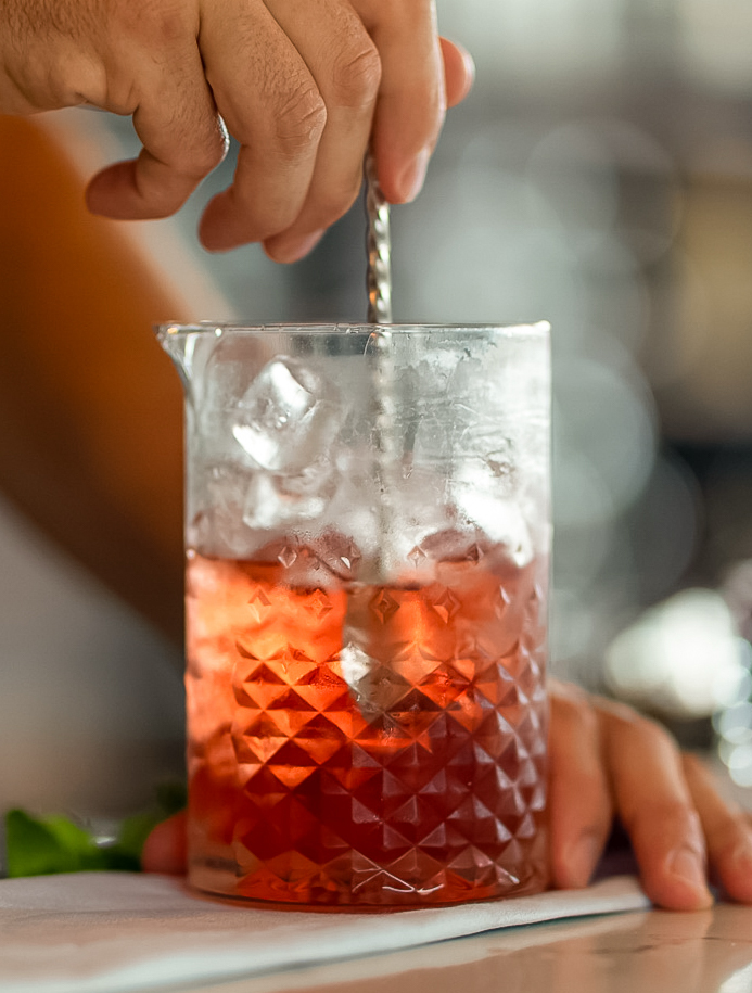 a person holding a straw in a glass
