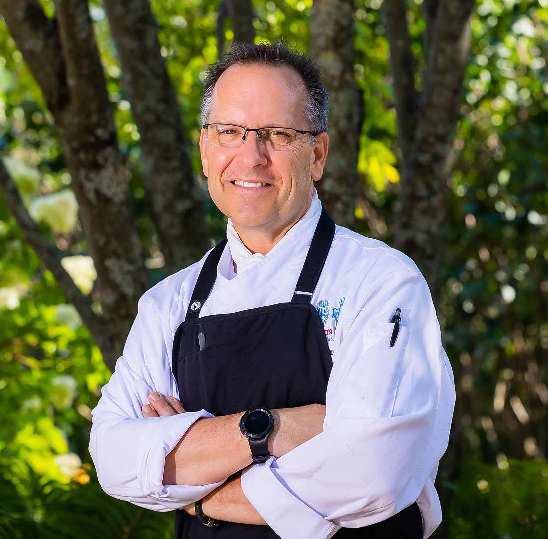 a man wearing a black apron and glasses