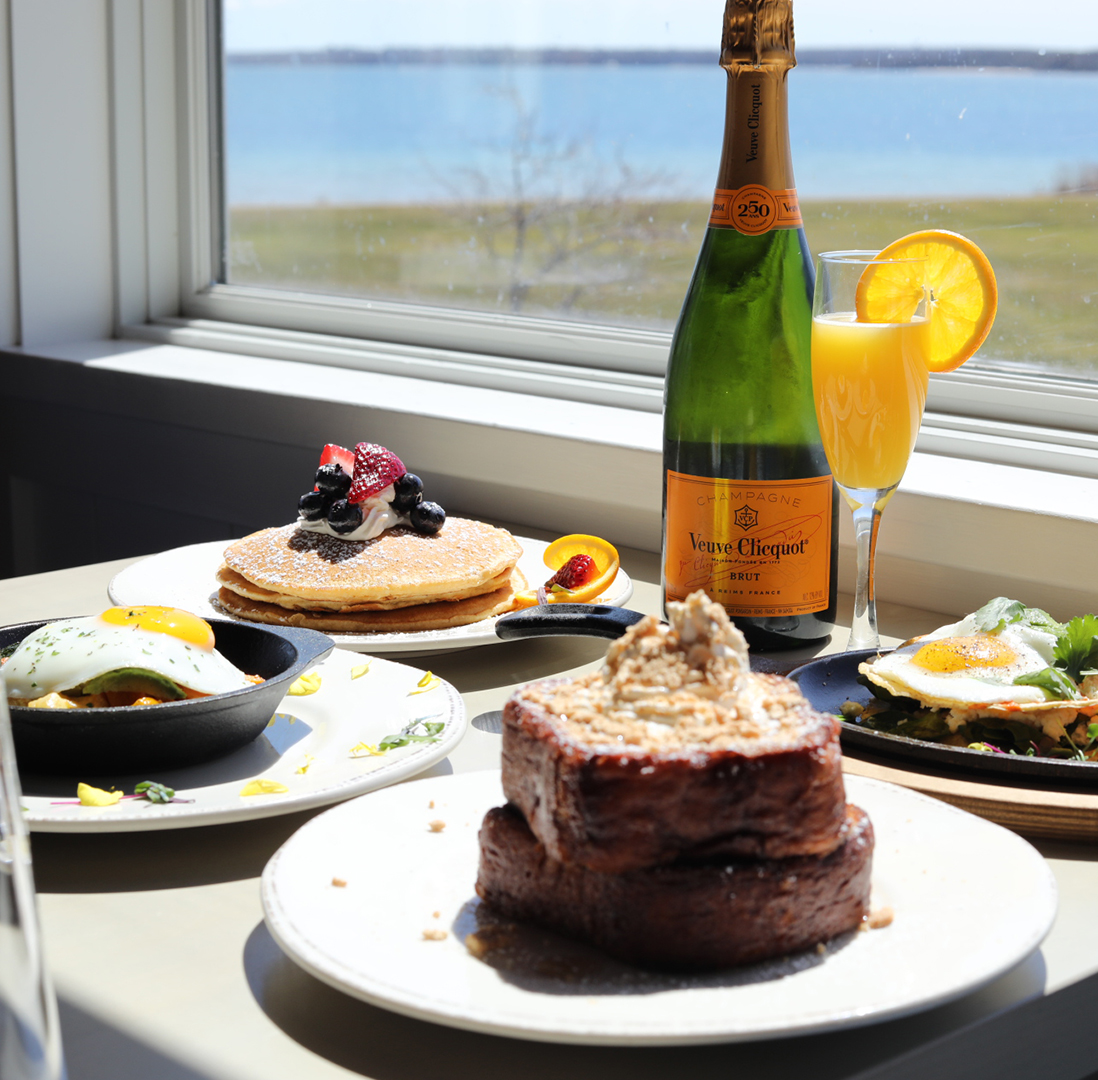 a table with plates of food and a bottle of champagne