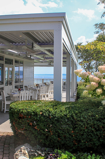 a white building with tables and chairs on a sunny day