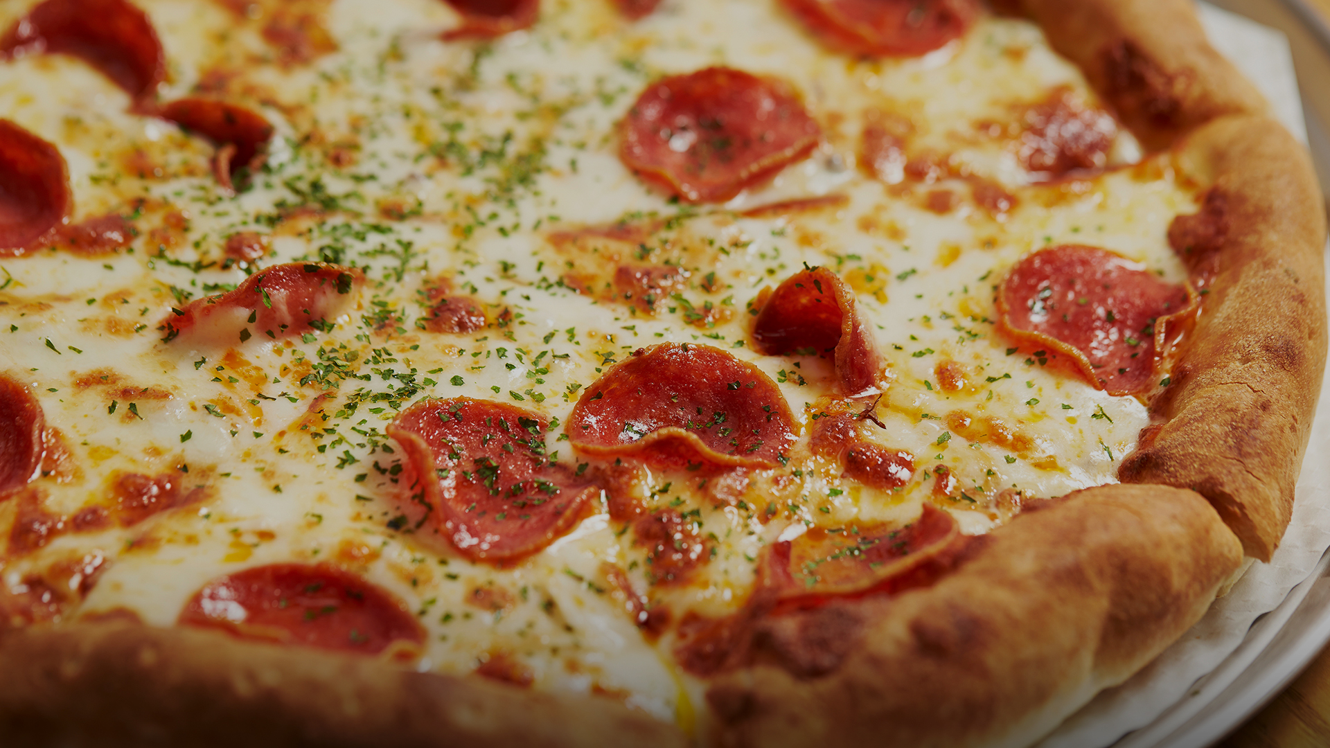 a pepperoni pizza with cheese and herbs