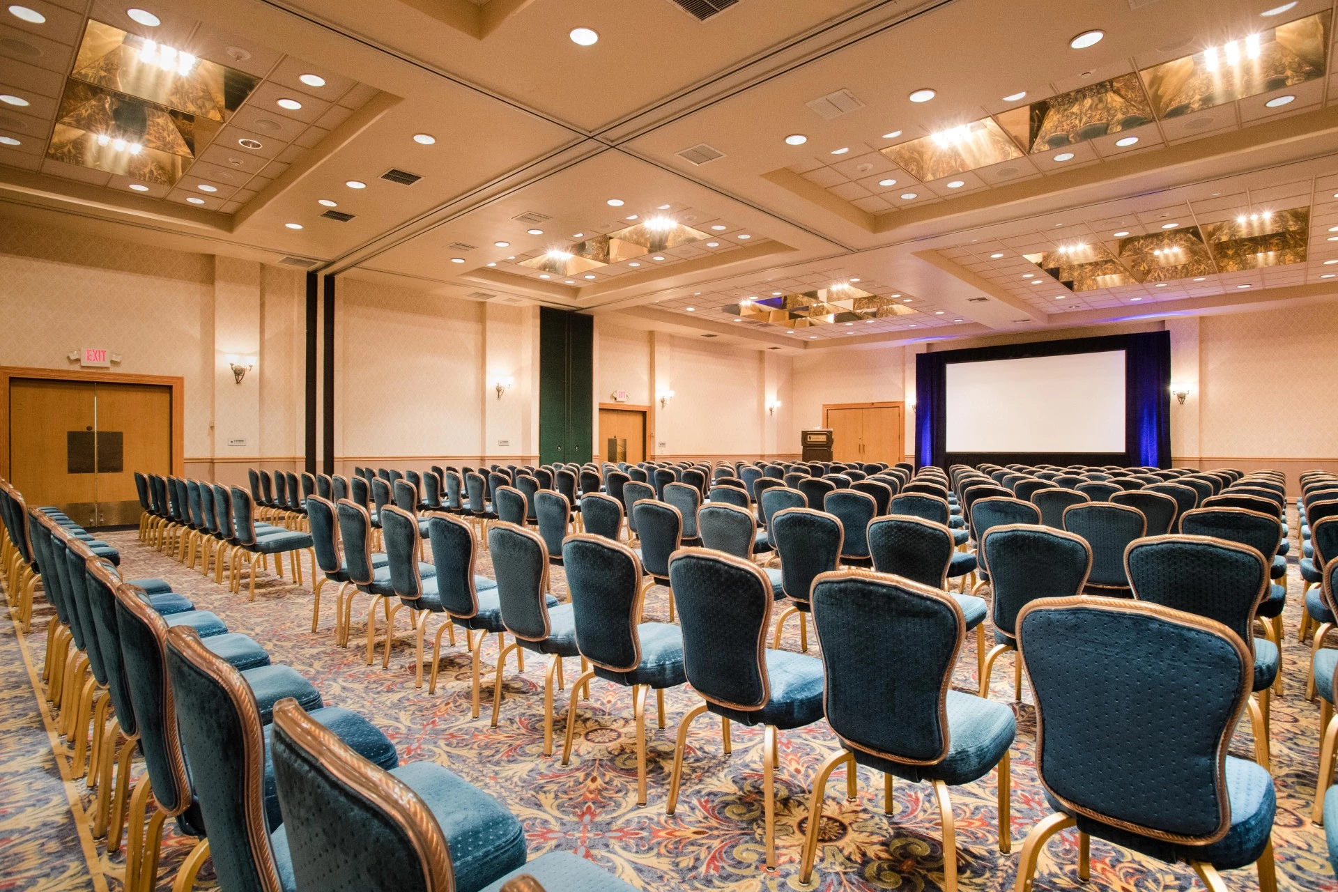 a room with blue chairs and a screen