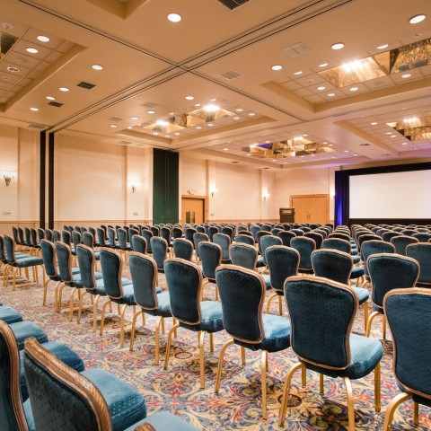 a room with blue chairs and a screen