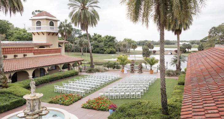 a wedding venue with white chairs and flowers