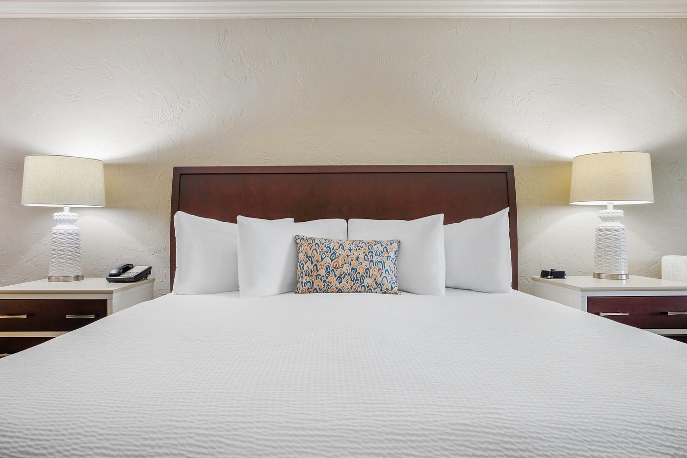 a bed with white sheets and pillows
