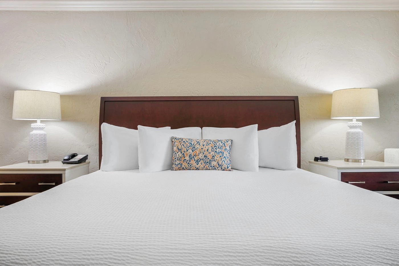 a bed with white sheets and pillows