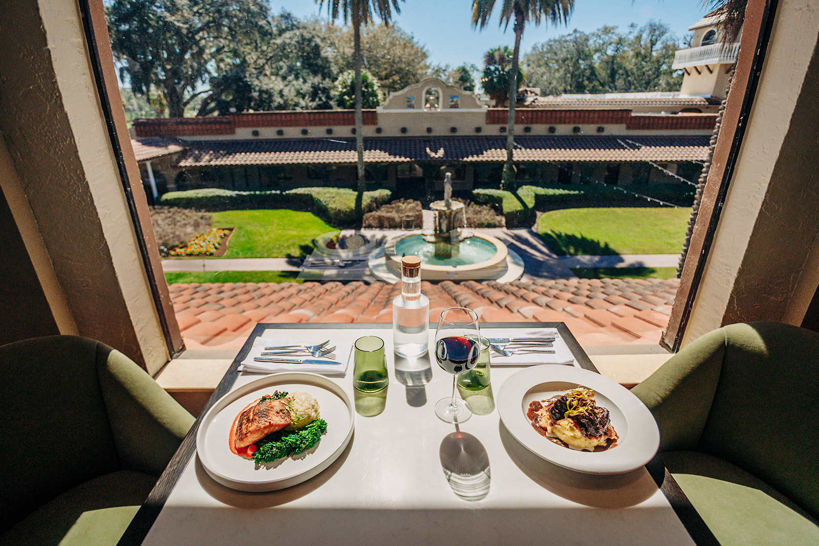 a table with plates of food and wine glasses on it