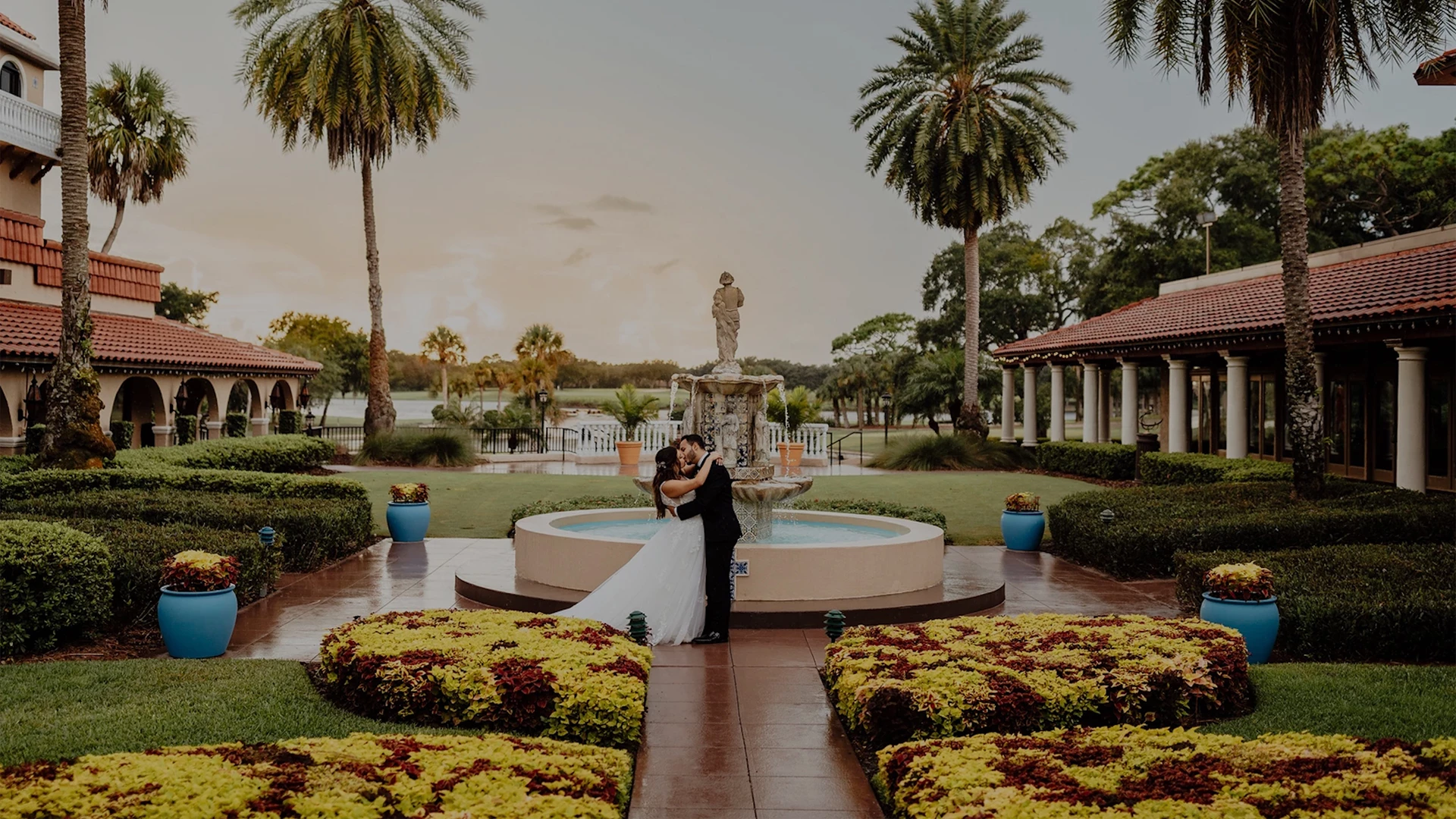 a man and woman hugging in front of a fountain