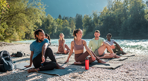 a group of people sitting on mats on a beach