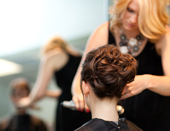 Hair stylist styling woman's hair