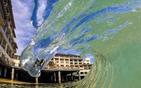 a wave of water with a building in the background