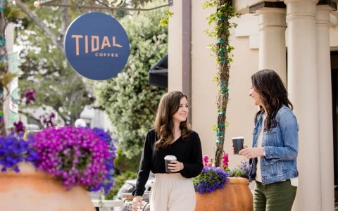 a couple of women holding coffee cups