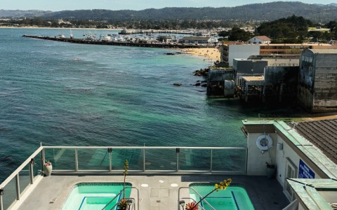 a rooftop with a pool and a body of water