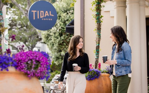 a couple of women holding coffee cups