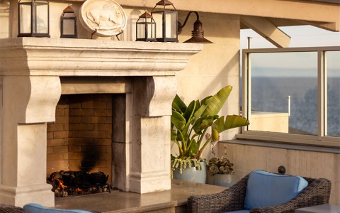 a fireplace with chairs and a table on a patio