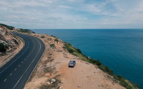 a car parked on a cliff by the ocean
