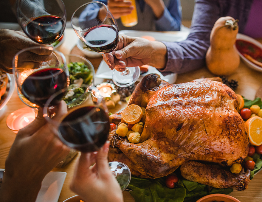 a group of people holding wine glasses over a turkey