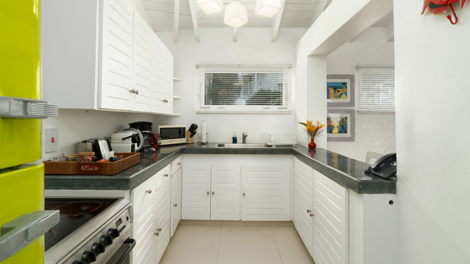 a kitchen with white cabinets and a black counter top