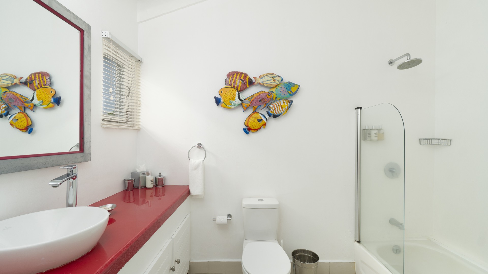 a bathroom with a red counter and a toilet