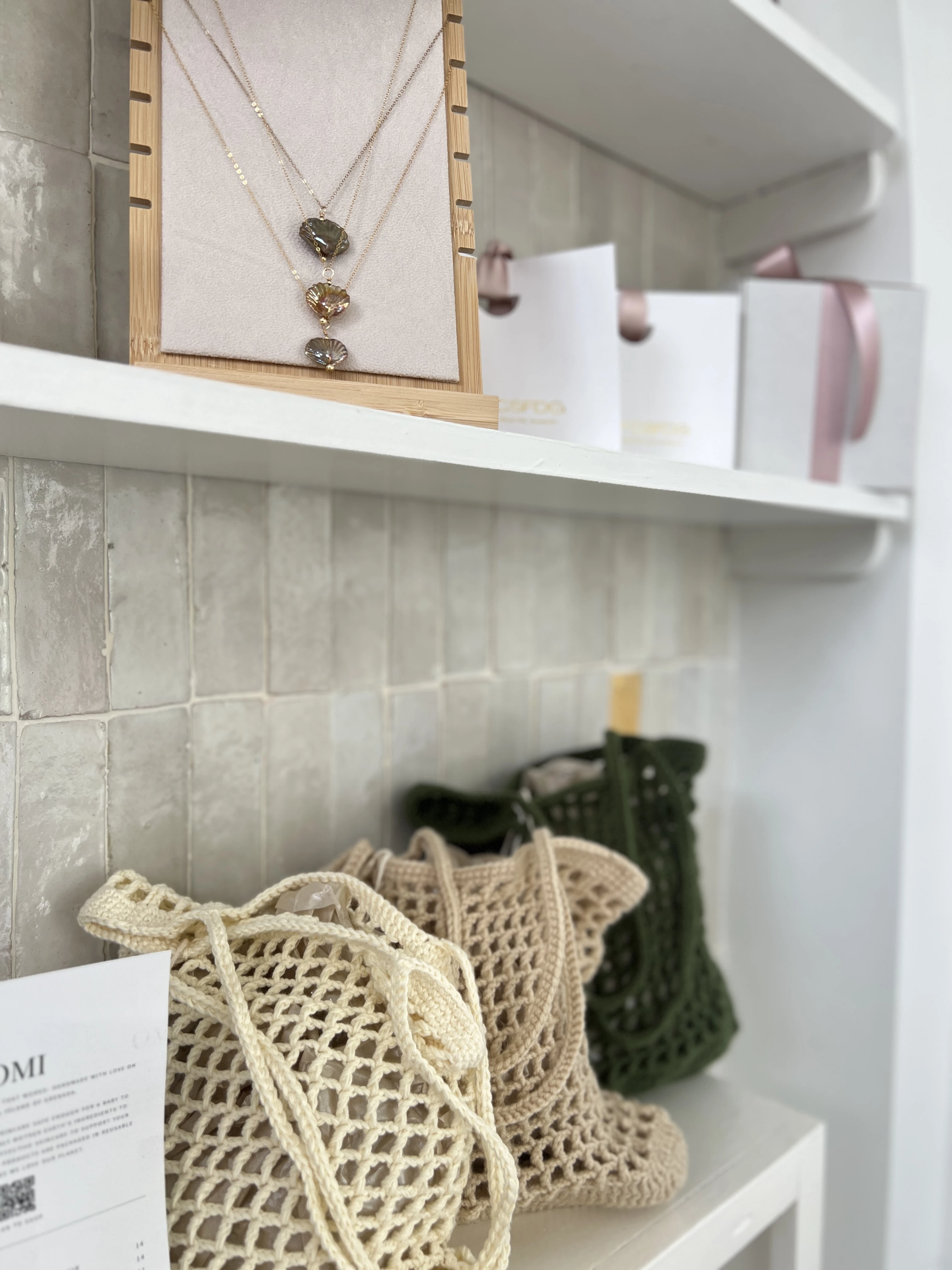 a shelf with a necklace and bags on it