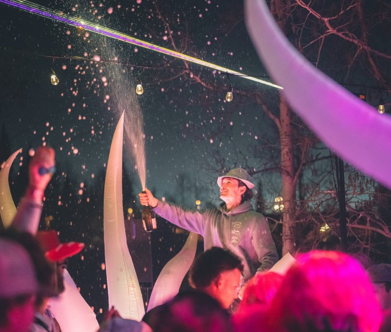 a man pouring champagne into a crowd of people