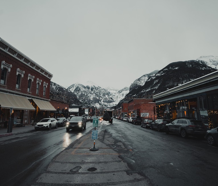 a street with cars and buildings in the background