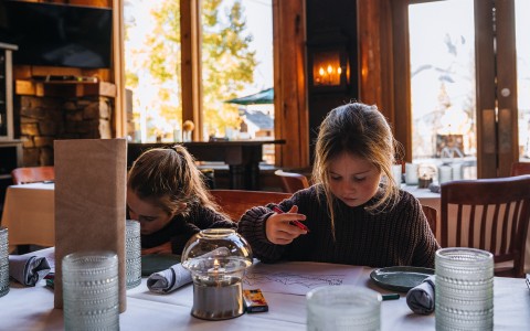 a two girls sitting at a table