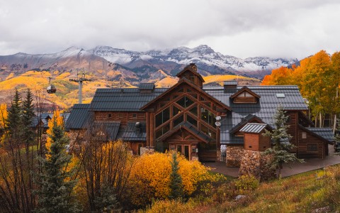 a house with trees and mountains in the background