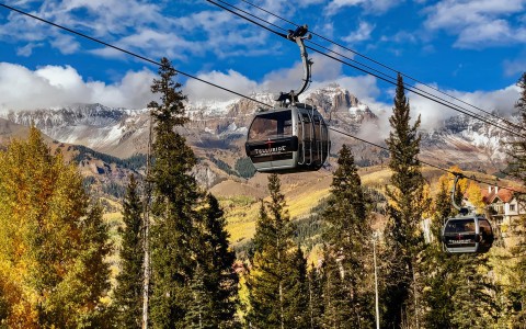a gondola with trees and mountains in the background