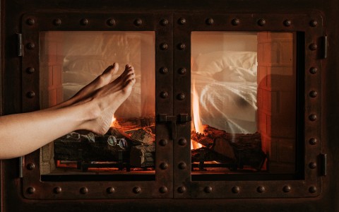 a person's feet in front of a fireplace