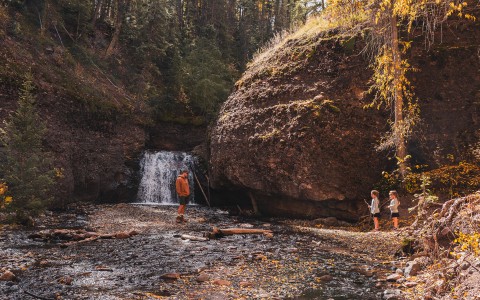 a man and child standing near a waterfall