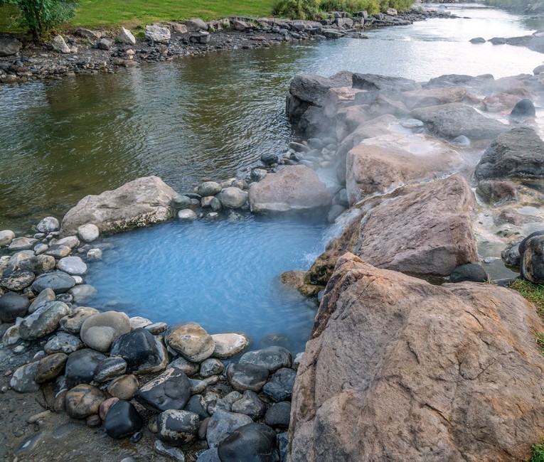 a river with rocks and a hot spring
