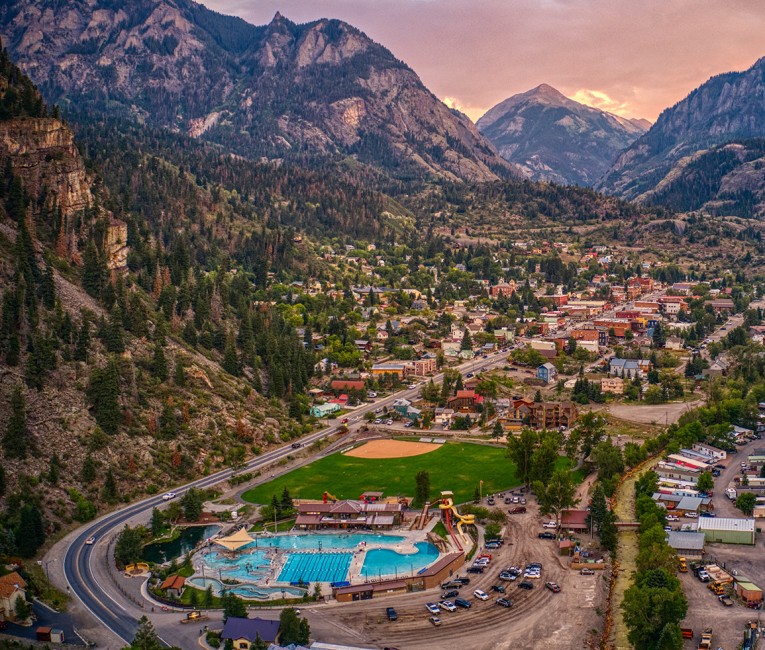 a town with a pool and a road in the mountains