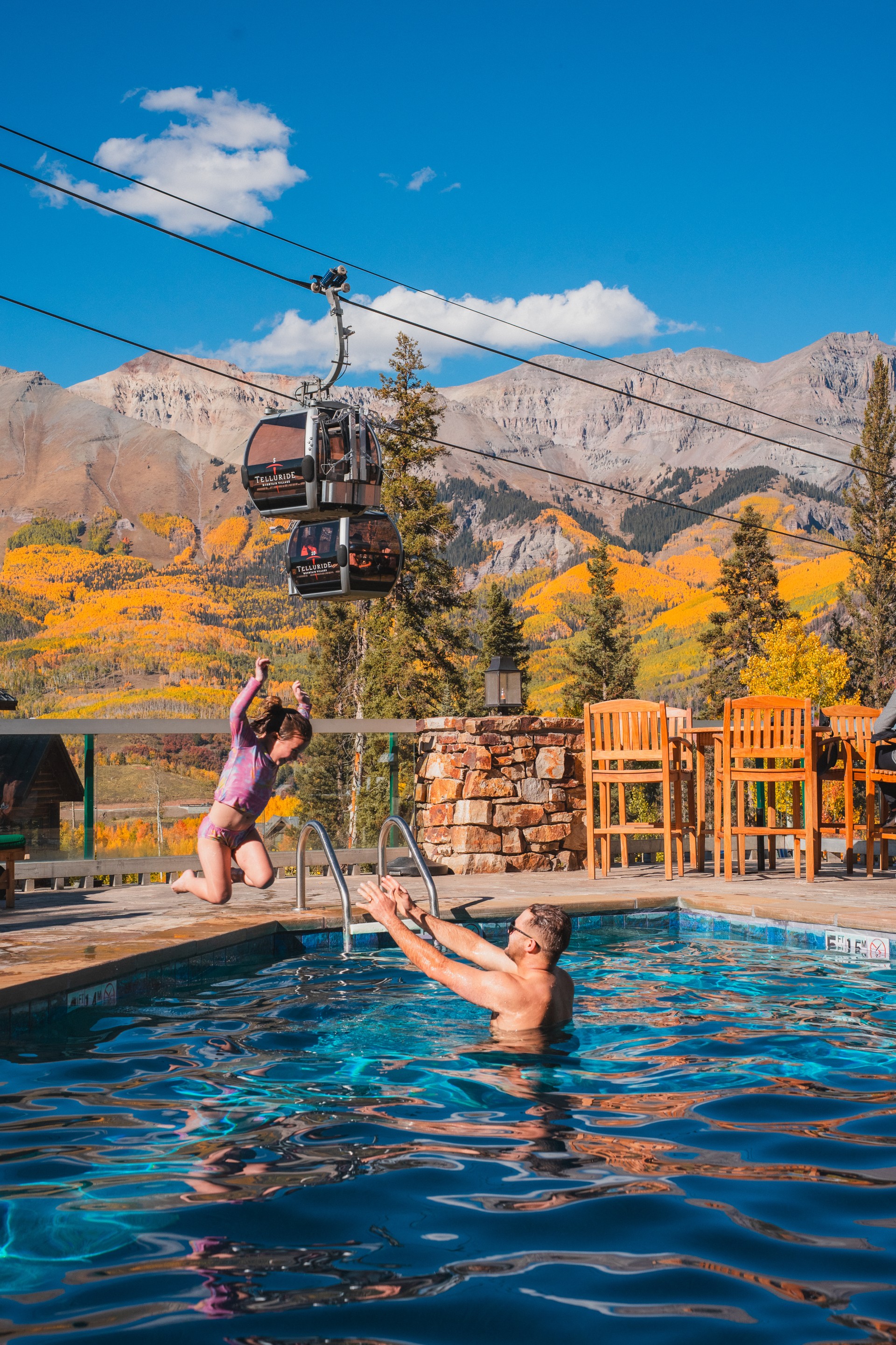 a man and girl jumping into a pool