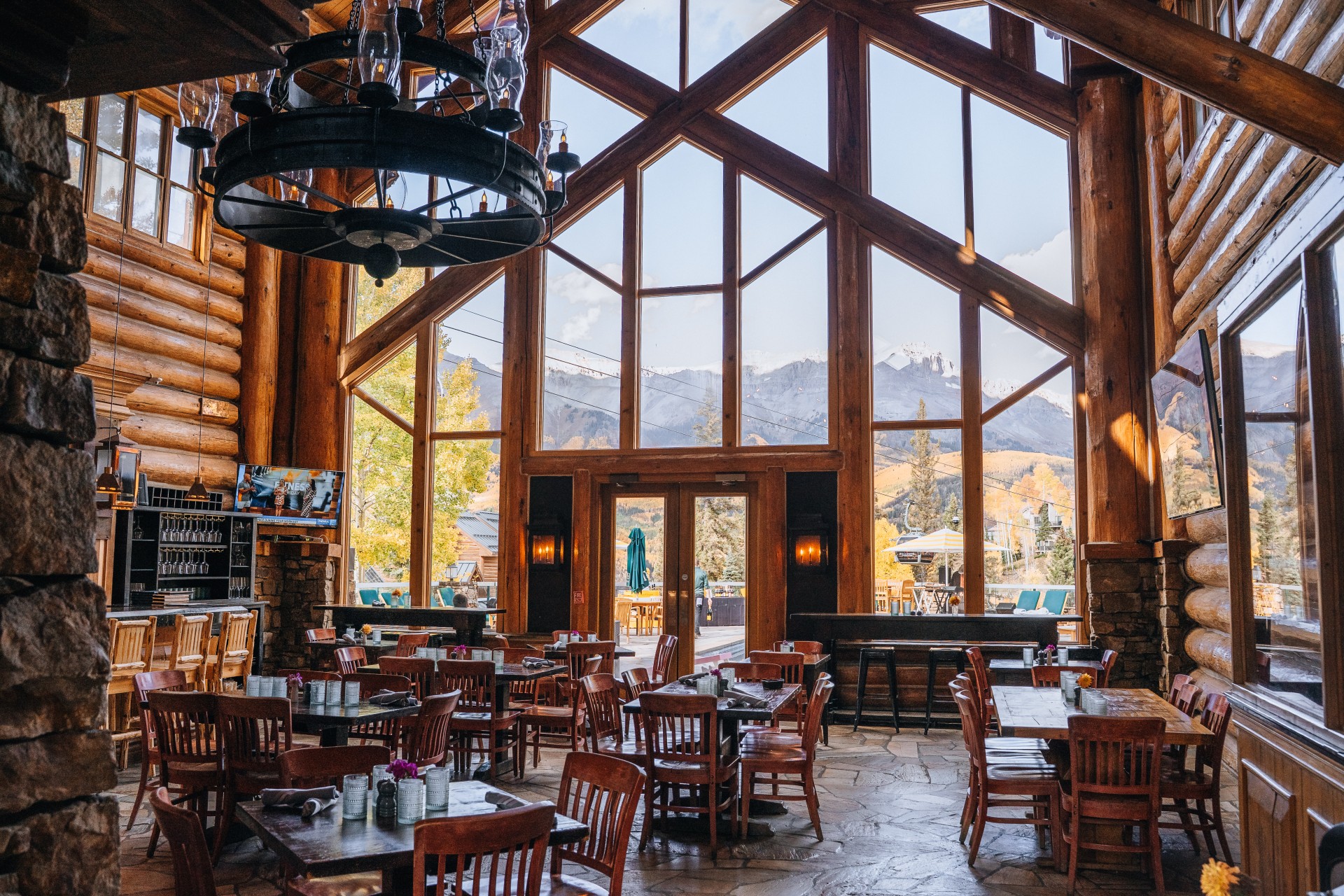 a room with tables and chairs in a log cabin