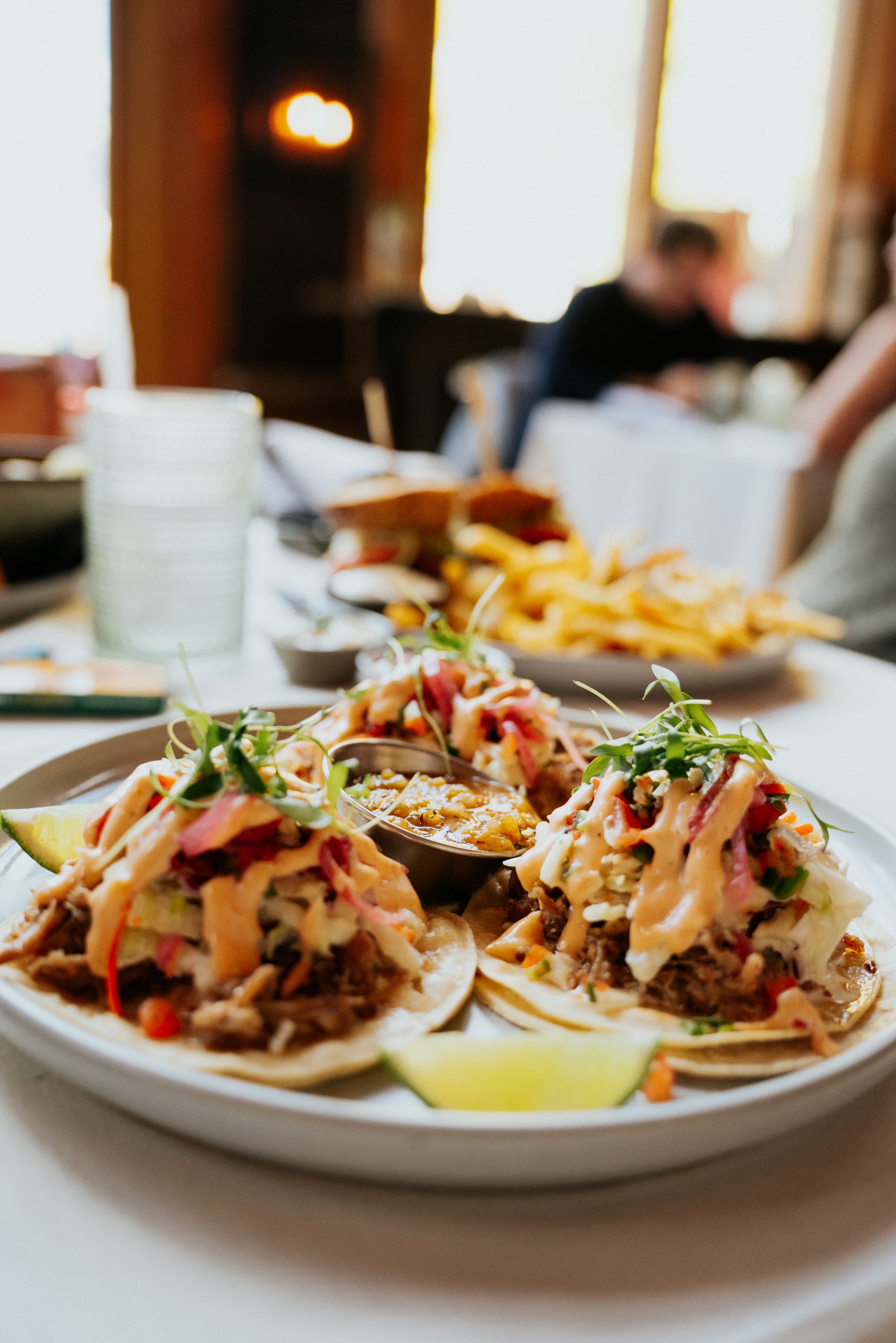 a plate of tacos with sauces and vegetables