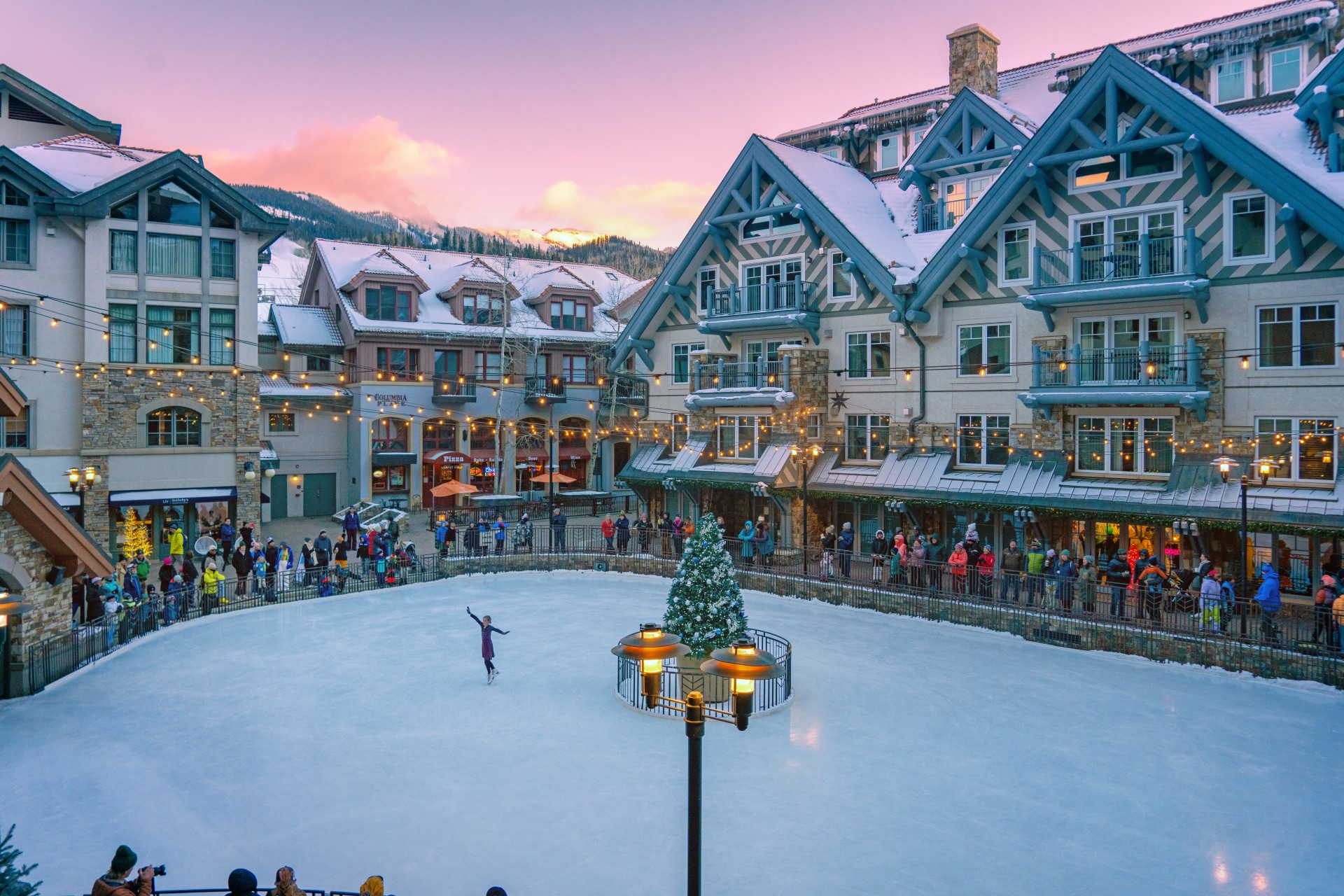 a group of people on an ice rink in front of a building