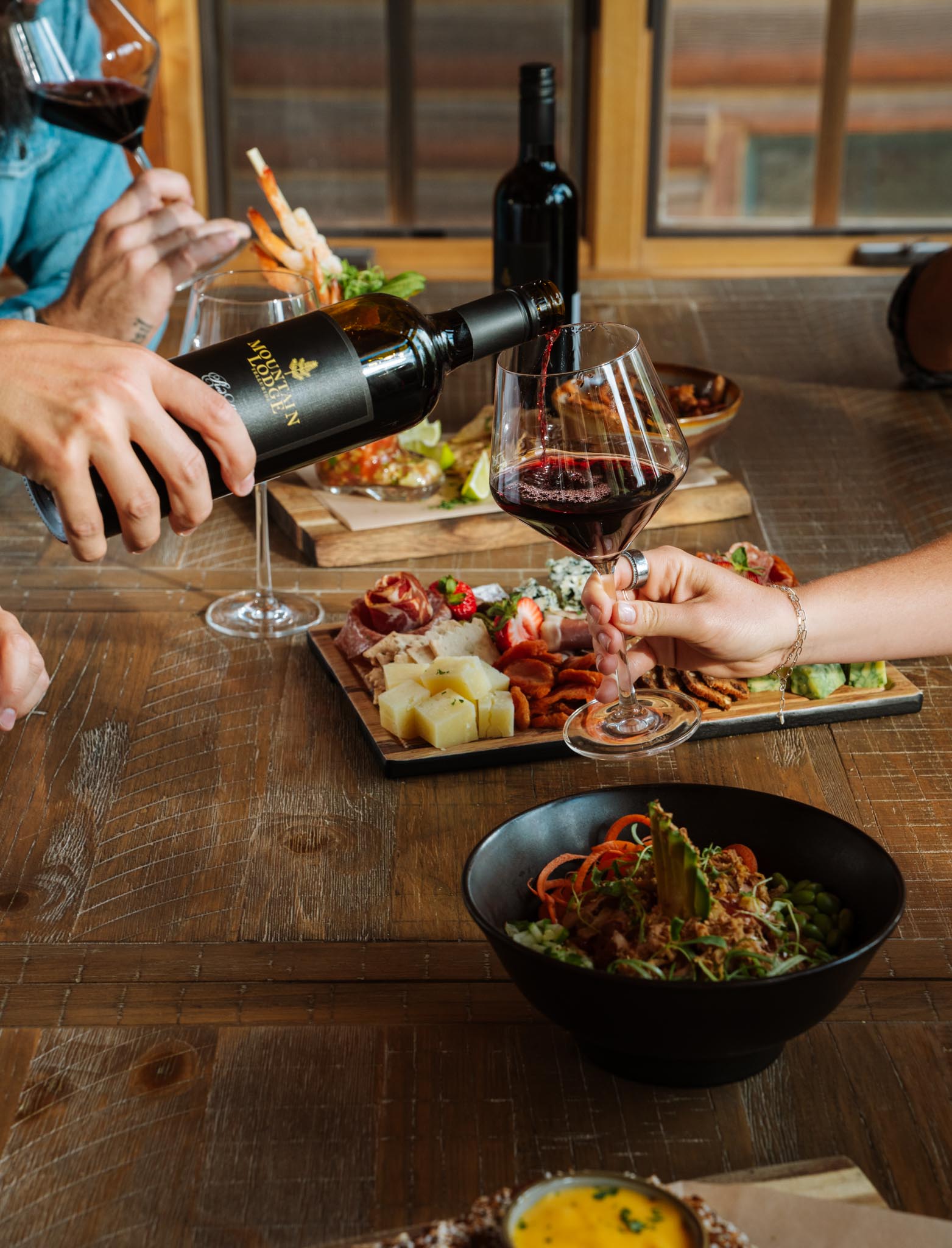 a person pouring wine into a glass