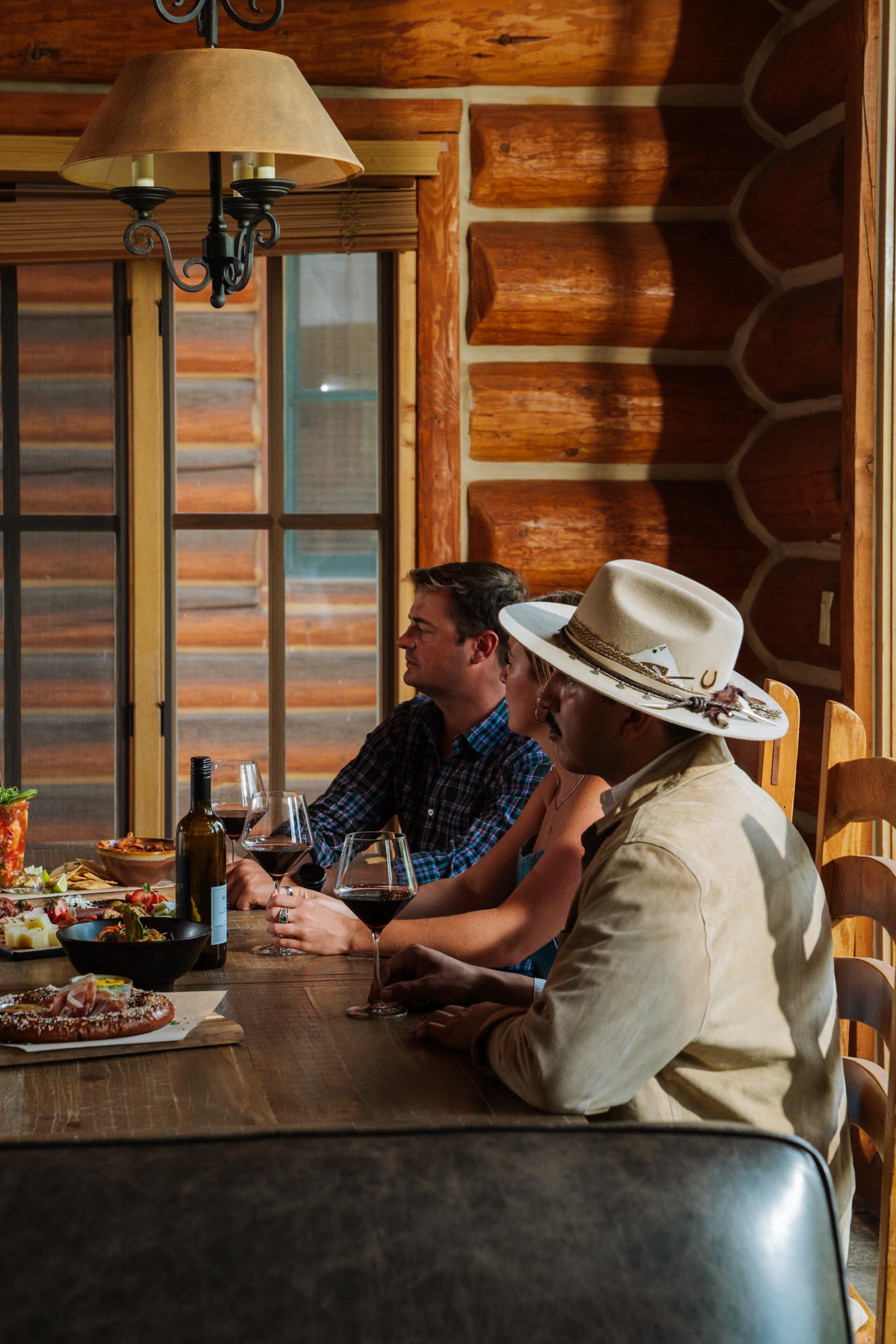 a group of people sitting at a table with food and drinks
