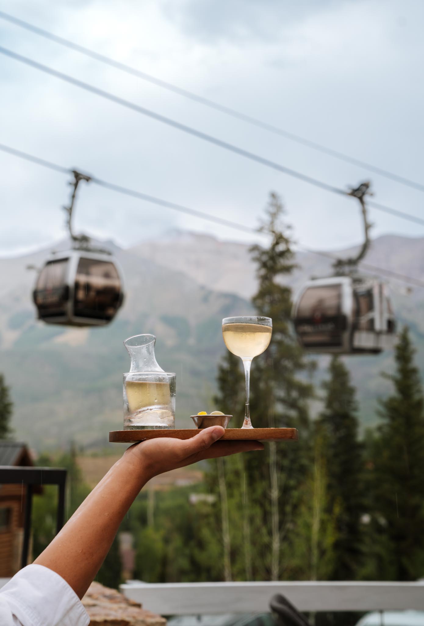 a hand holding a tray with a drink and a bowl on it