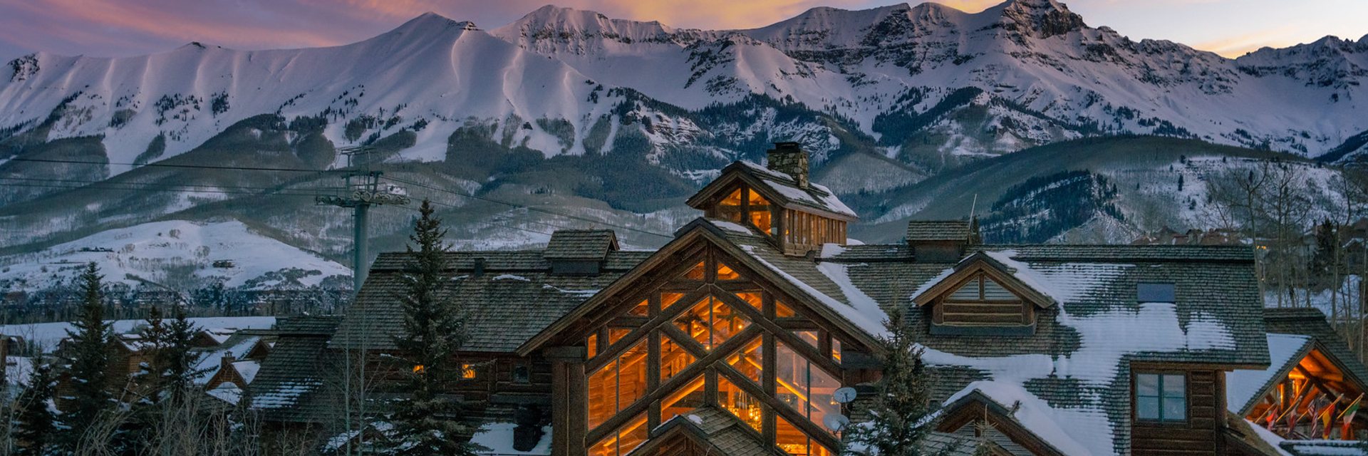 Mountain Lodge Telluride at sunset, with the snowy San Juan Mountains behind it