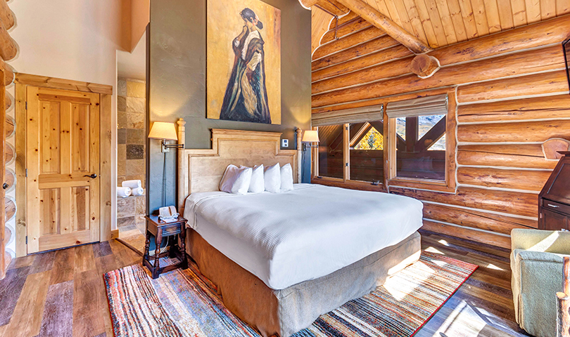 a bedroom with a large bed and a painting on the wall