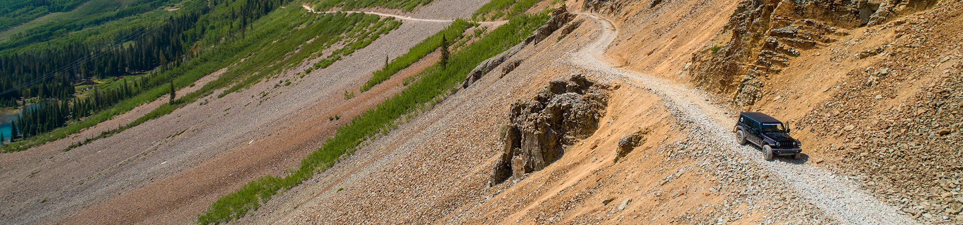 a rocky hill with a path and trees