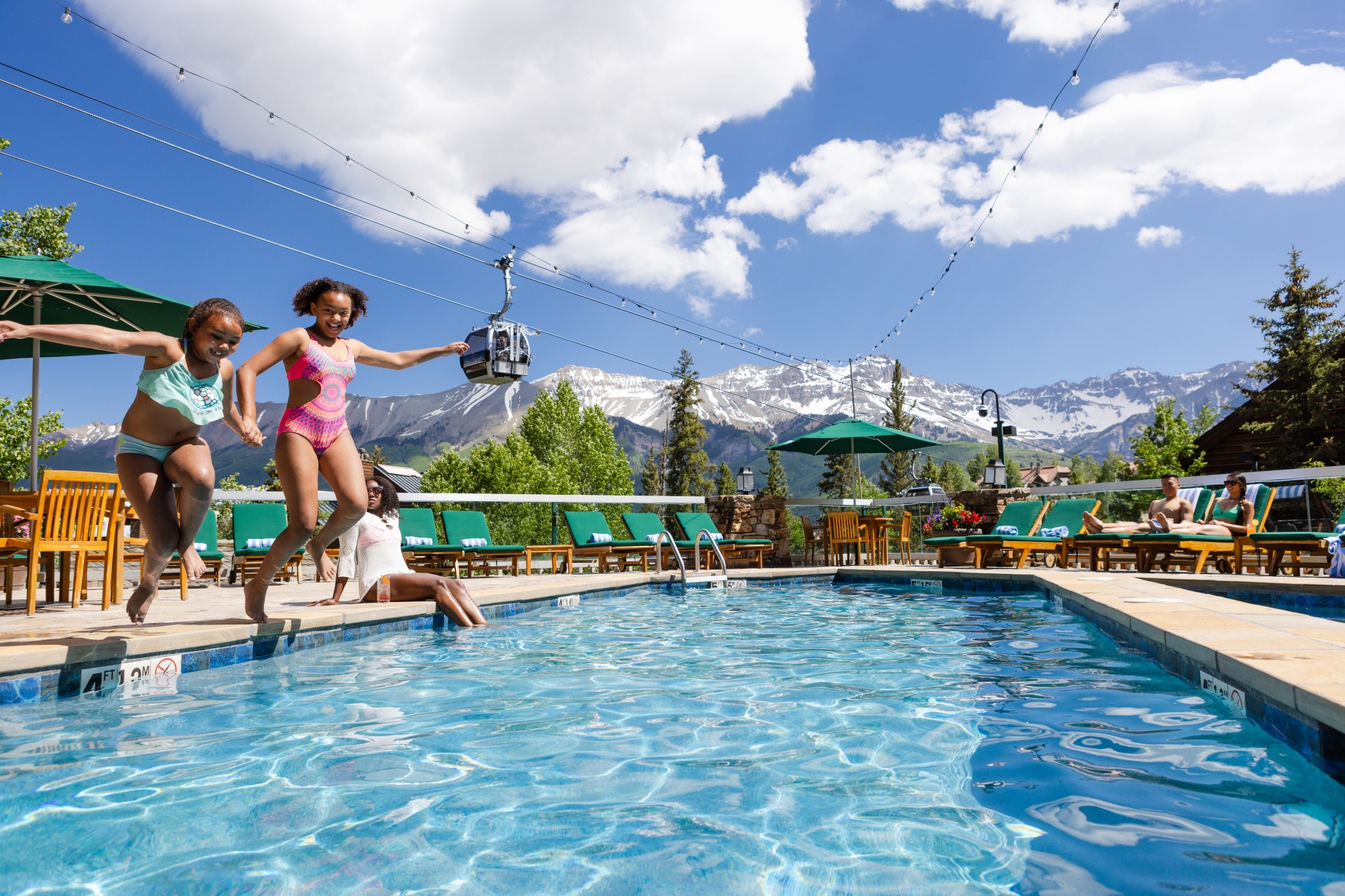 a group of kids jumping into a pool